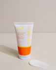 Texture blanche de la crème solaire SPF 50+ Héliabrine déposée à côté du tube