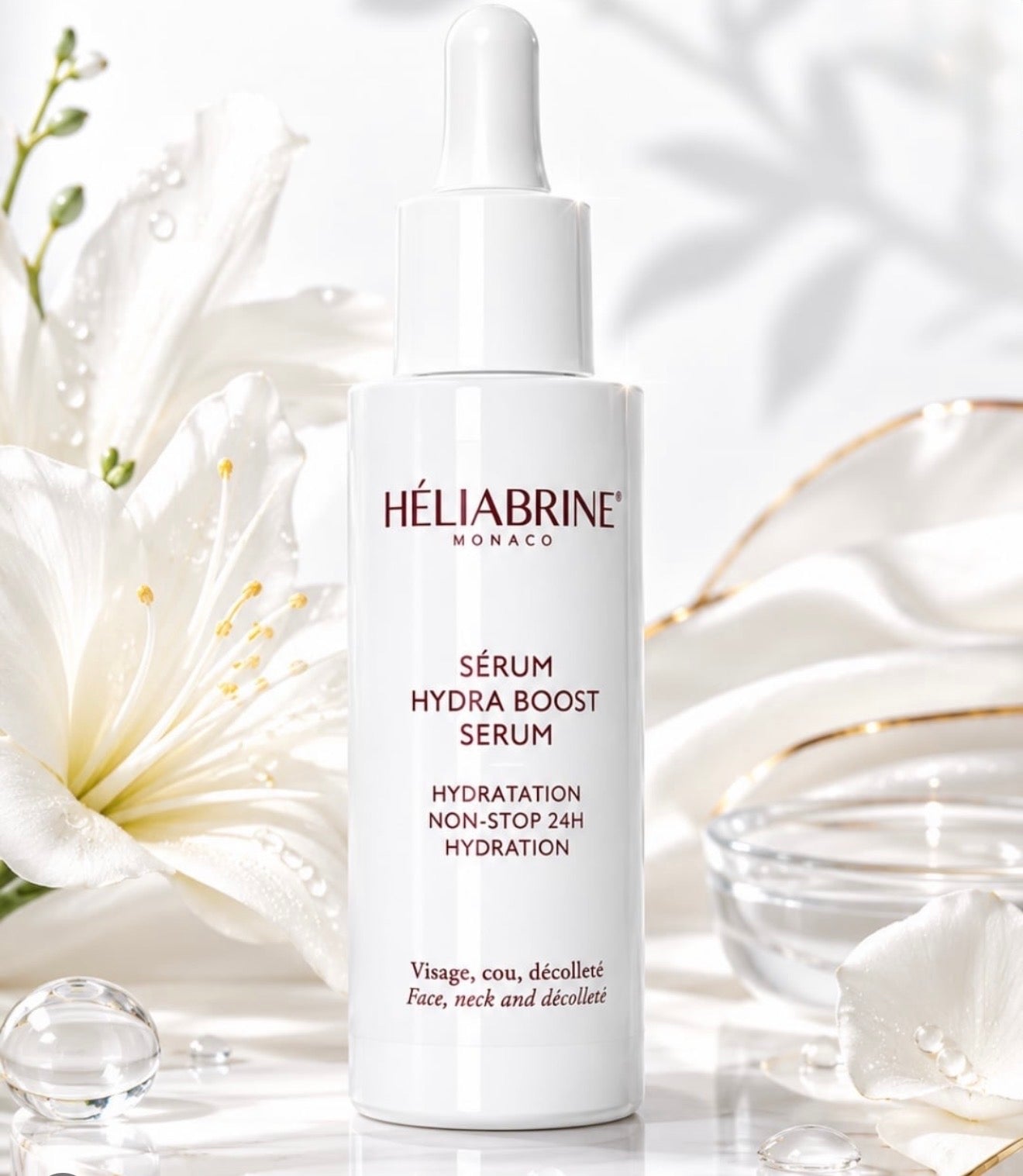 Sérum Hydra-Boost Héliabrine 30 ml, flacon compte-gouttes blanc posé près d'un lys
