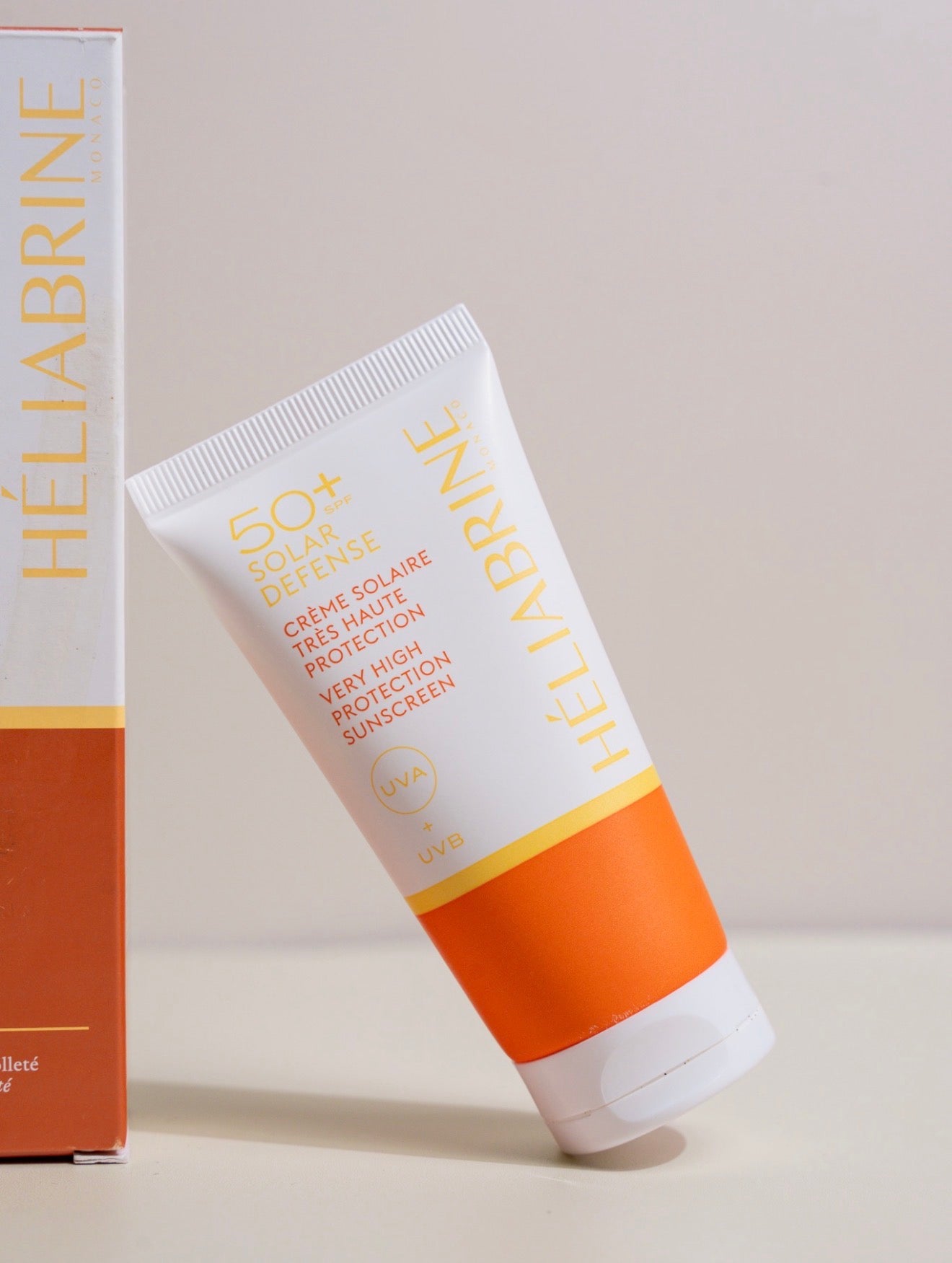 Solar Defense SPF 50+ Héliabrine appuyé contre son étui, gros plan sur l'étiquette